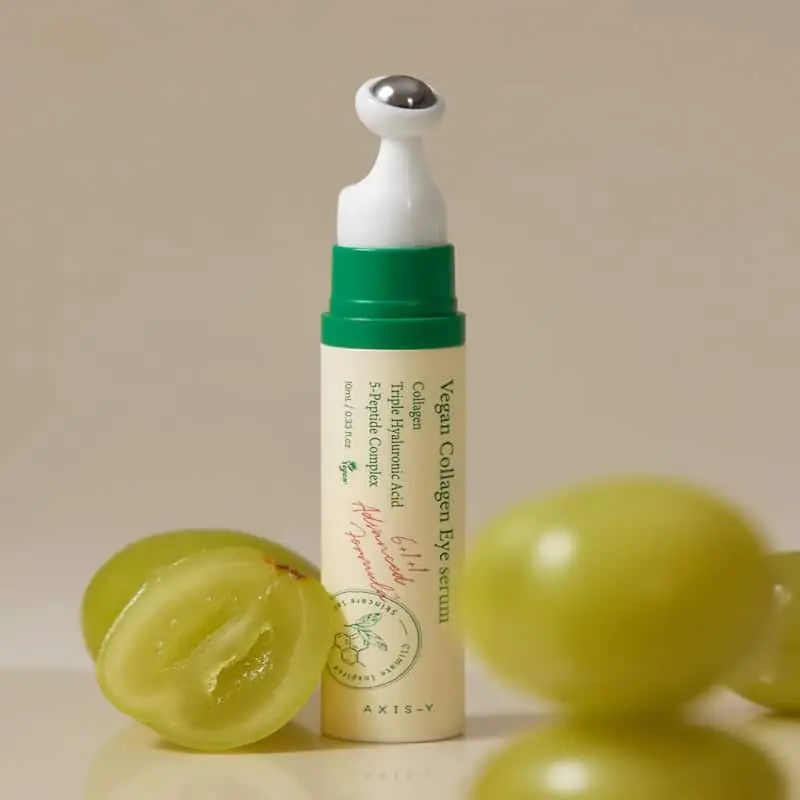 A hand gently holding the slender Axis-y Vegan Collagen Eye Serum 10ml bottle. - thumbnail