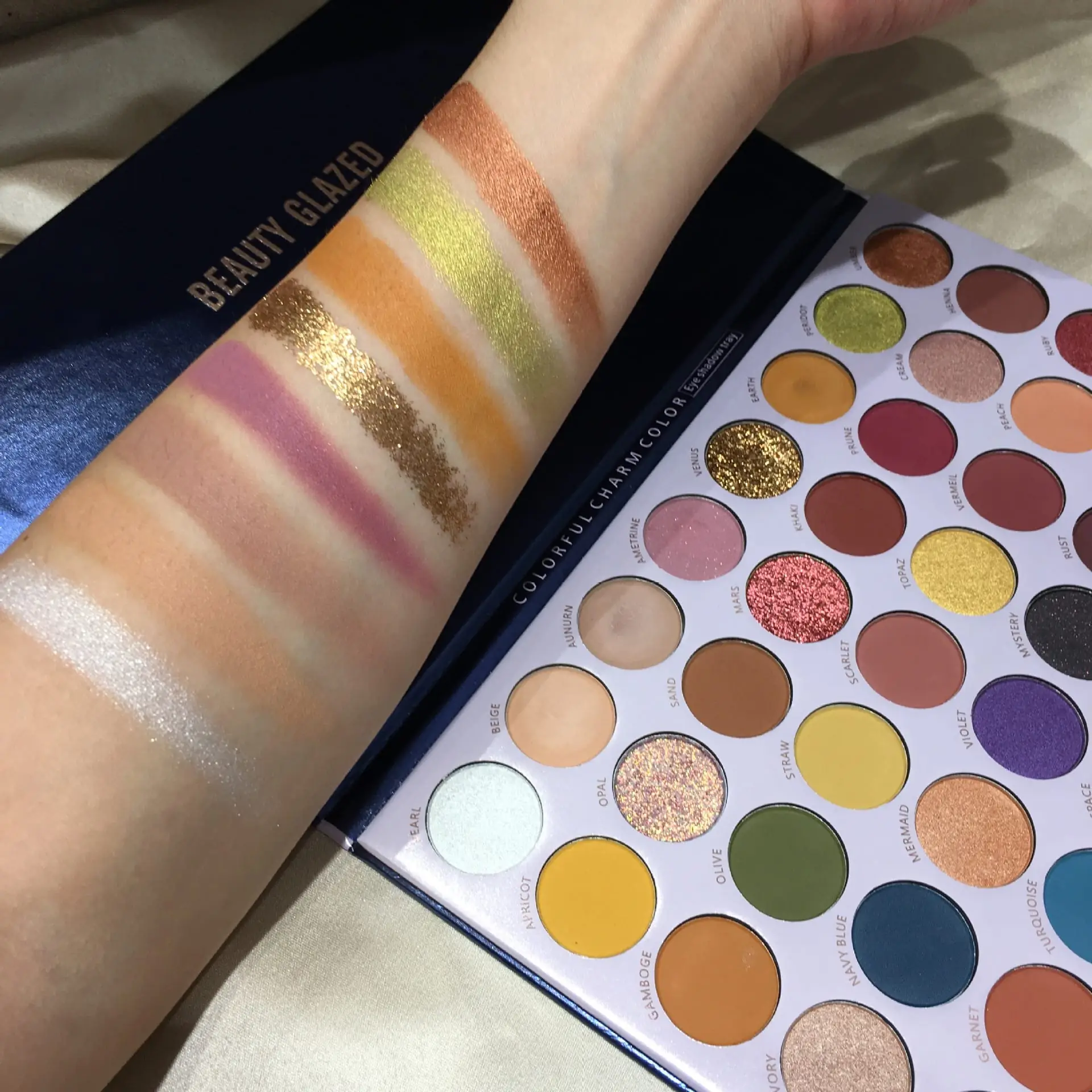 Beauty Glazed Reversal Planet eyeshadow shades swatched on an arm, displaying vibrant pigment and varied finishes. - thumbnail