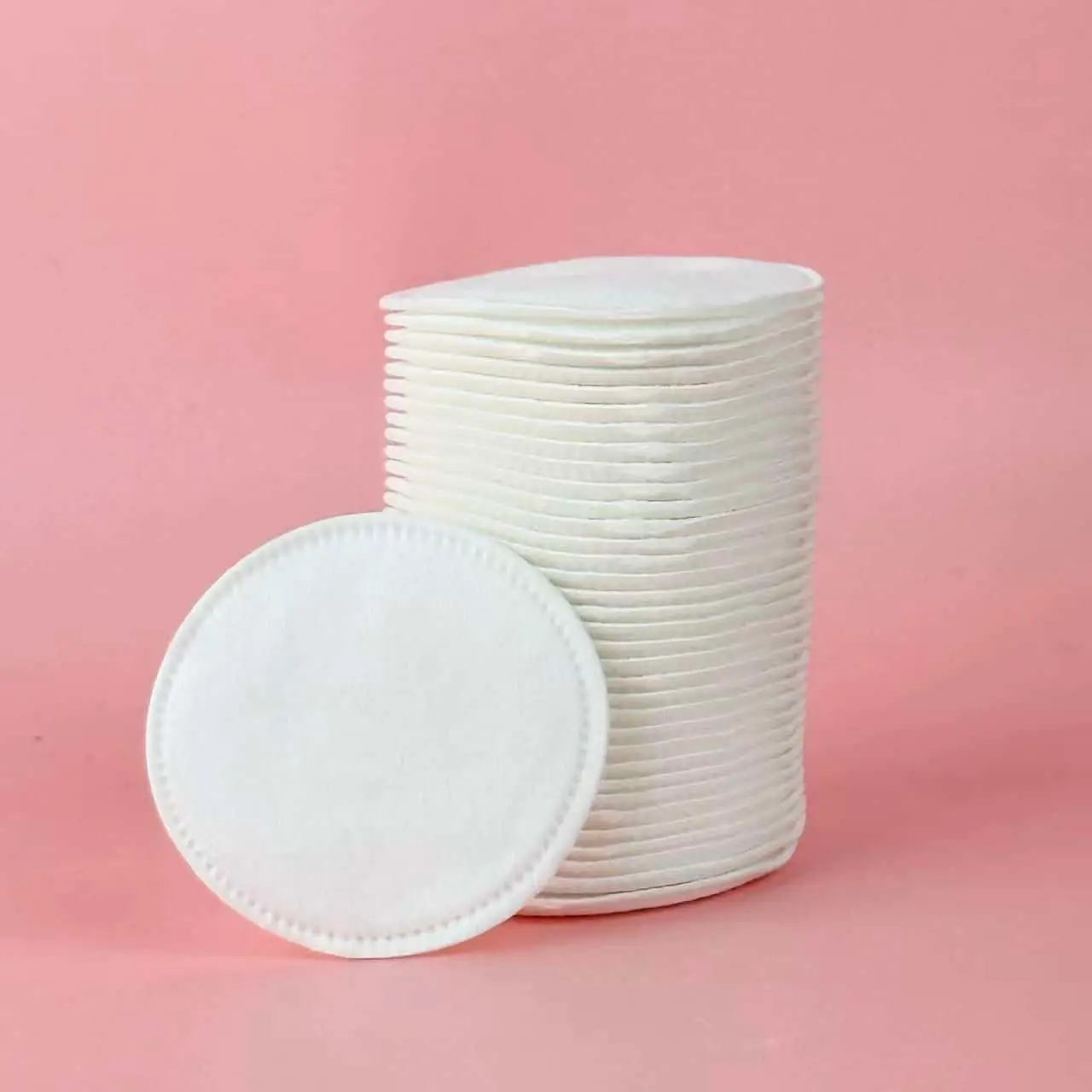 A hand gently holding a soft Caplino pure cotton pad, demonstrating thickness. - thumbnail