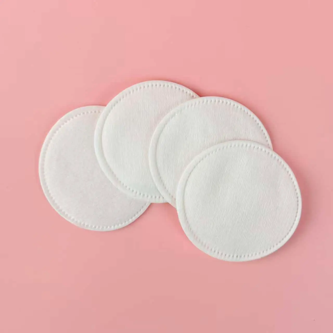 Fresh stack of Caplino cosmetic cotton pads, showing side profile and thickness. - thumbnail