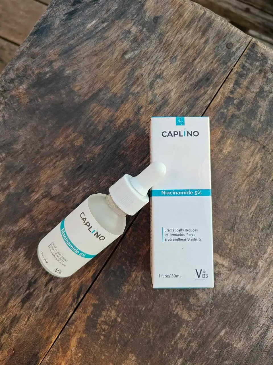 Two Caplino Dark Spot and Pore Solution bottles arranged horizontally on a light textured surface. - thumbnail