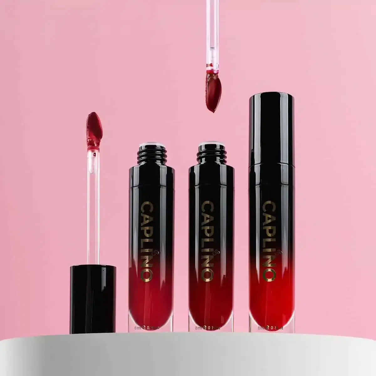 Hand holding Caplino Liquid Matte Lipstick, applicator slightly out, revealing Nude Glow shade. - thumbnail