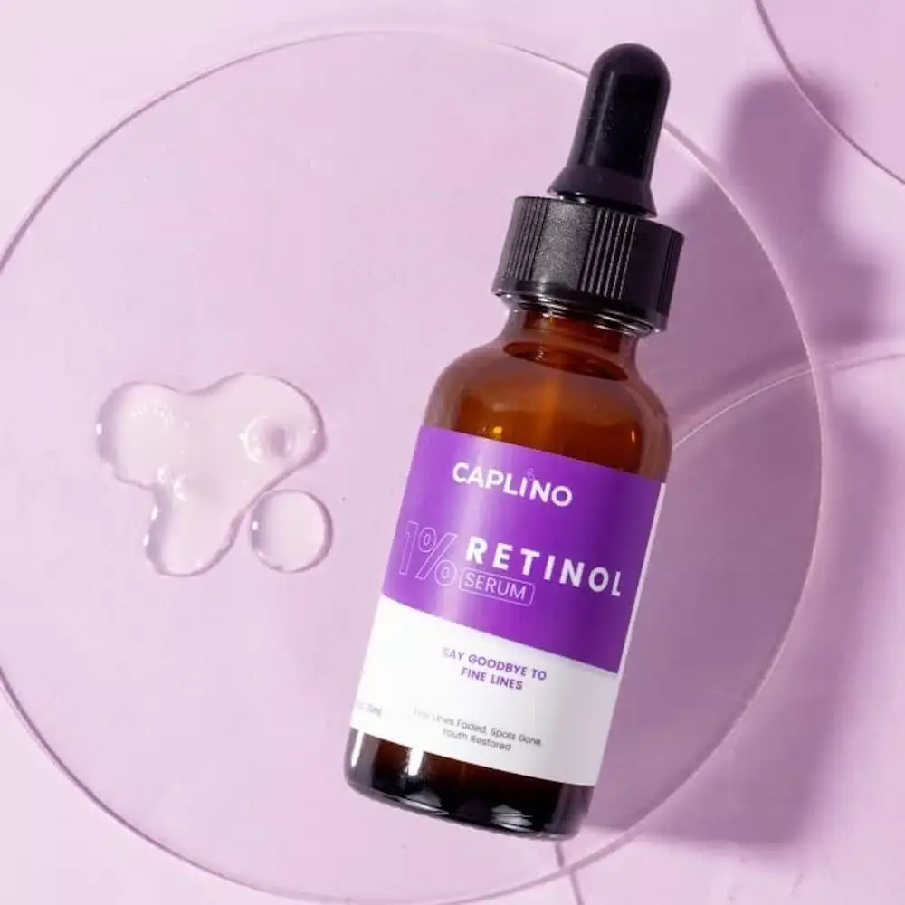 Hand applying a single drop of Caplino 1% Retinol Serum onto the back of another hand. - thumbnail