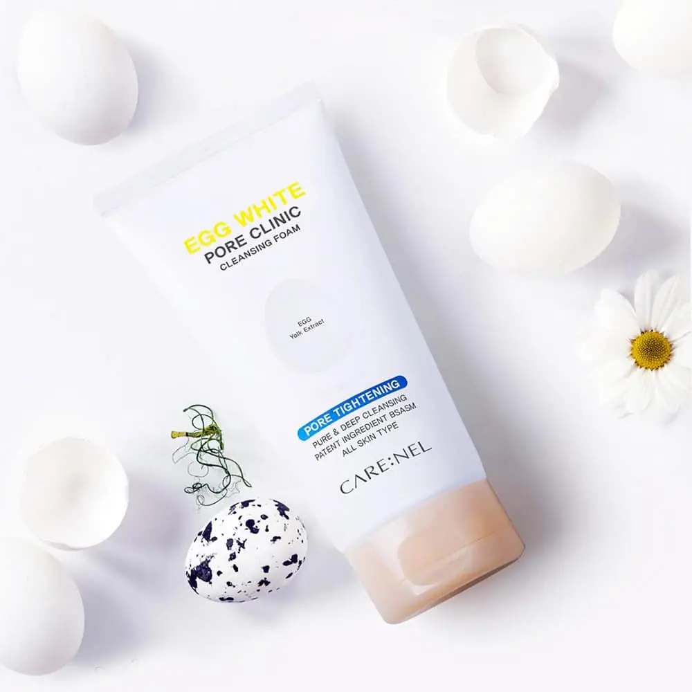 Carenel Egg White Pore Clinic Cleansing Foam tube displayed with a small bowl of egg whites. - thumbnail