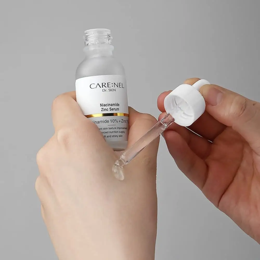 Close-up of the Carenel Niacinamide serum's clear liquid being dispensed from dropper. - thumbnail