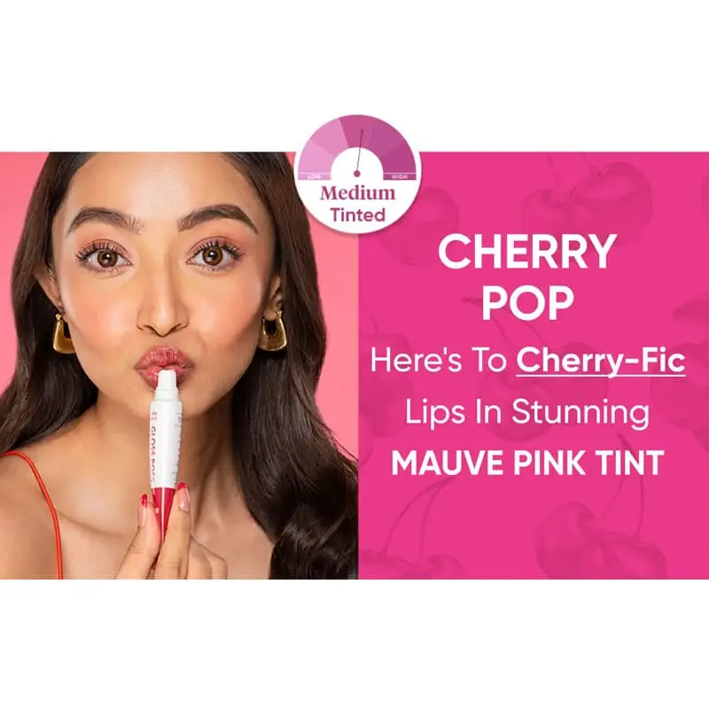 Dot & Key Cherry Pop lip balm next to fresh red cherries and green leaves. - thumbnail