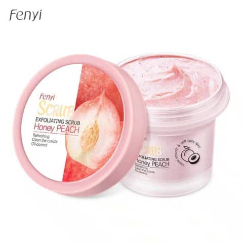 Fenyi Honey Peach exfoliating body scrub in a vibrant pink tube, standing with a fresh peach fruit.