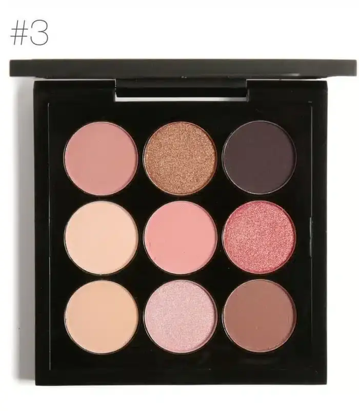 Hand applying Focallure eyeshadow to eyelid with brush, palette in background. - thumbnail