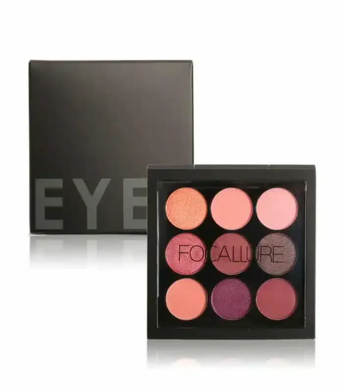 Focallure 9-color eyeshadow palette open with makeup brushes scattered around it. - thumbnail