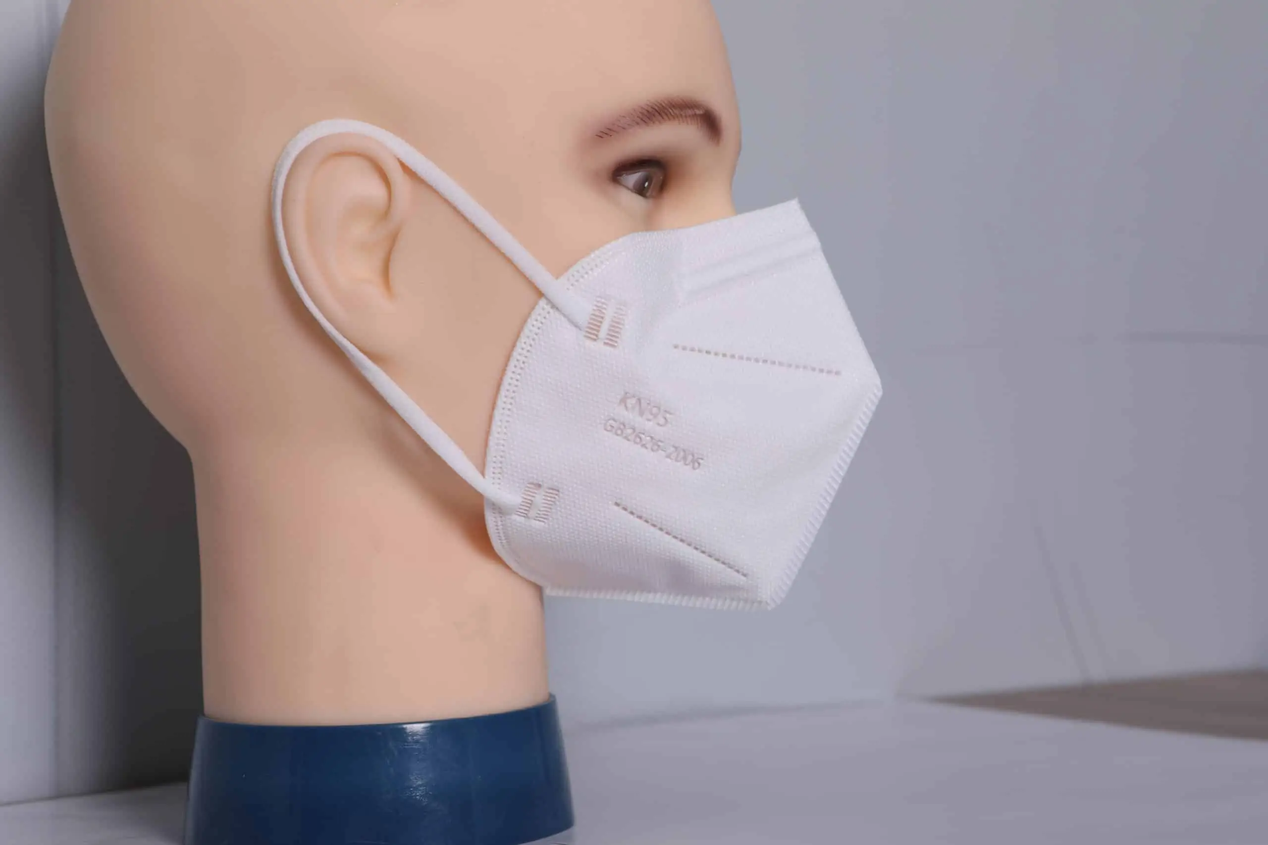 Folded white RuSu KN95 mask shown from a side angle, emphasizing its ergonomic shape. - thumbnail