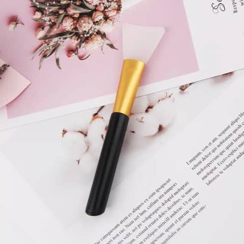 Laikou black silicone facial mask applicator brush featuring a flexible spoon head and clear ergonomic handle.