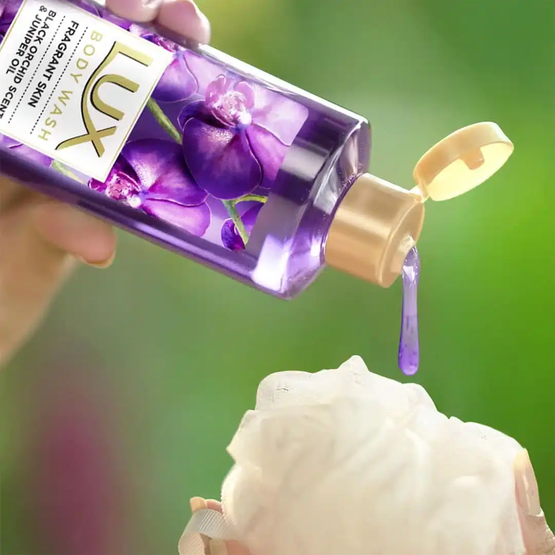 Three Lux Body Wash bottles, dark purple with gold pumps, lined up on a white background. - thumbnail