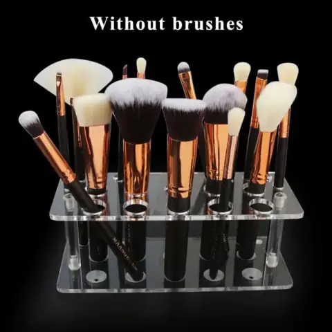 Maange transparent acrylic makeup brushes holder with white pearls and assorted pink-handled brushes.