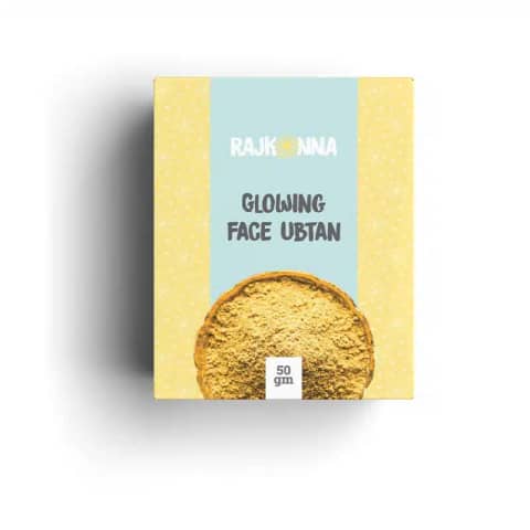 Rajkonna Face Glowing Ubtan 50gm, a transparent jar revealing fine yellow powder, front view.