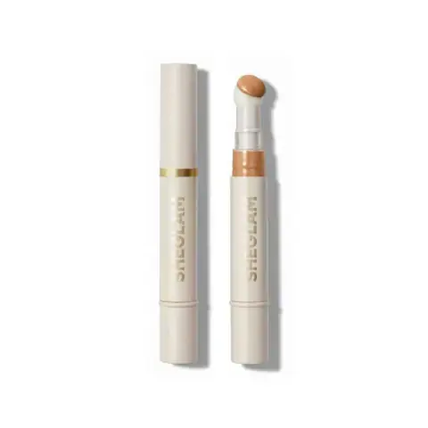 Sheglam liquid concealer in Honey shade, full tube standing upright with doe-foot applicator visible.