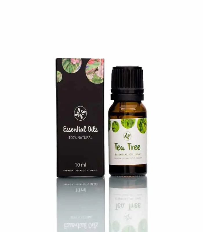 Skin Cafe Tea Tree Essential Oil bottle with dropper held above, showing a single oil drop. - thumbnail