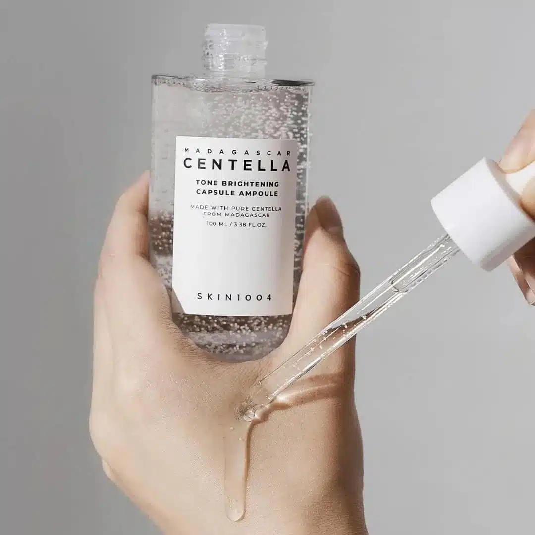 Skin1004 Centella Tone Brightening Ampoule dispensed showing yellow serum with visible white capsules and dropper. - thumbnail