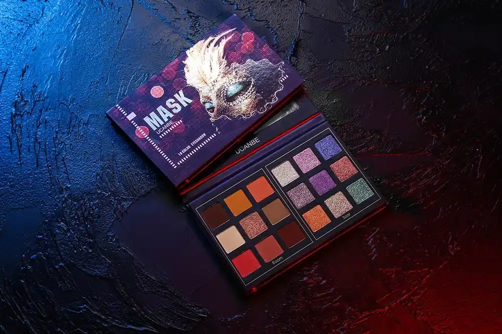 UCANBE Mask Eyeshadow Palette open, revealing 18 vibrant and neutral eyeshadow colors with a brush. - thumbnail