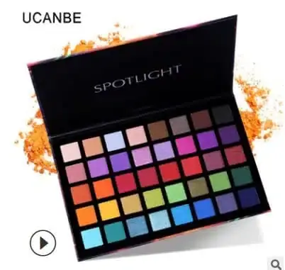 UCANBE Spotlight Eyeshadow Palette held in hand, showing its size and wide array of vibrant shades. - thumbnail