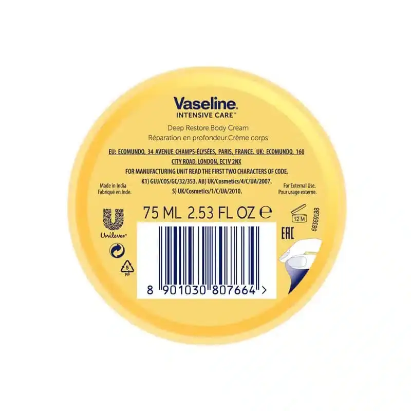 Hand squeezing Vaseline Deep Restore Body Cream 75ml, revealing white cream texture on fingers. - thumbnail