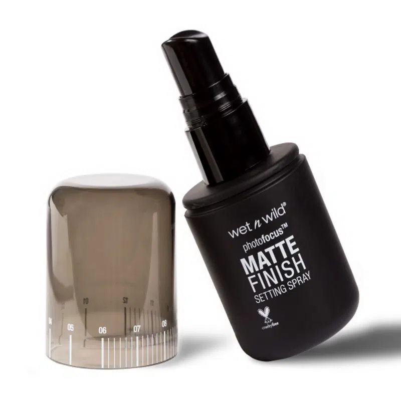Hand holding Wet N Wild Photo Focus Matte Setting Spray bottle, ready for application with fine mist. - thumbnail